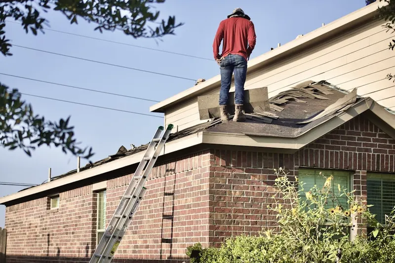 Professional roofer working on a residential roof in Charles River Village